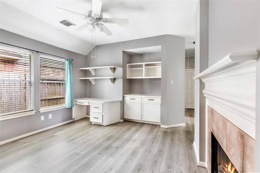 Flex-space with built-in cabinets, desk, and fireplace.