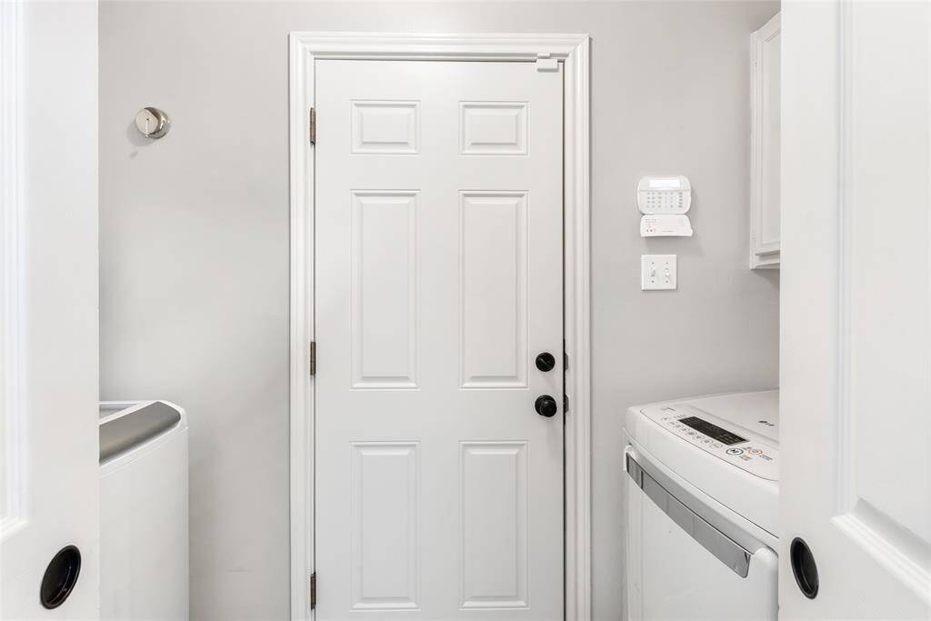 Laundry room with built-in cabinets above both the washer and dryer.