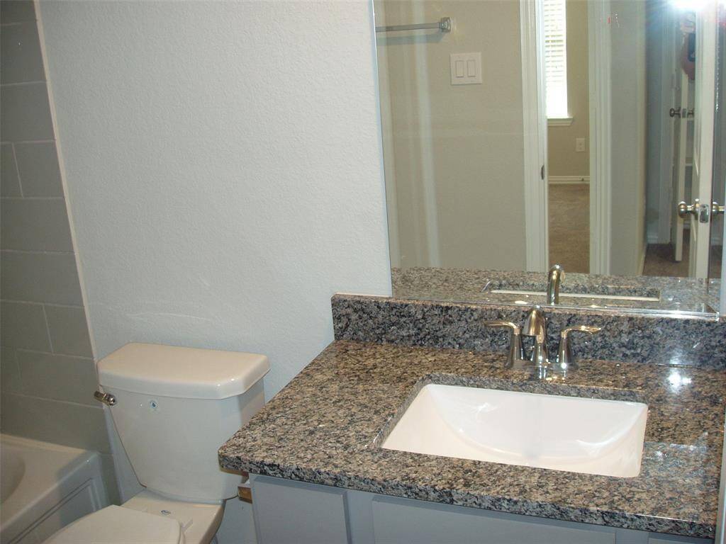 Upstairs full guest bathroom with granite counters and under mount sink.