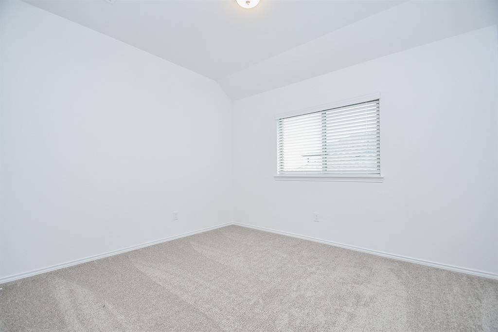 Higher placed double windows in a carpeted secondary bedroom allow more room for favorite furnishings.