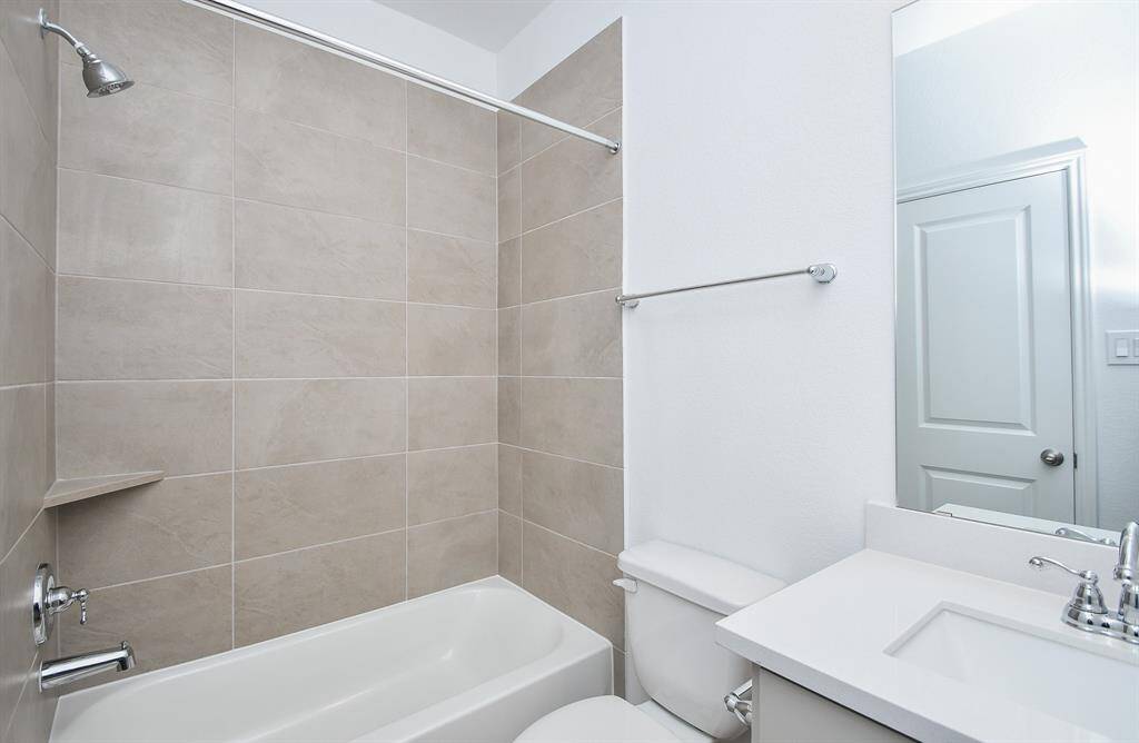 Don't you love the giant, earth toned tile surround in this combined shower/bathtub in a second bathroom?