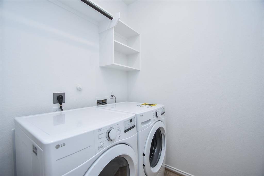 The utility room is equally bright and spacious, easily hosting dual laundry appliances, with handy storage, above.