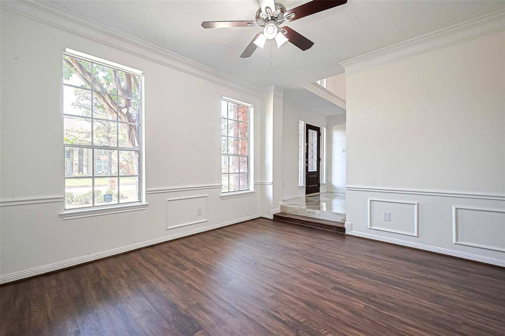 Dining room features double crown molding and a ceiling fan with a light fixture