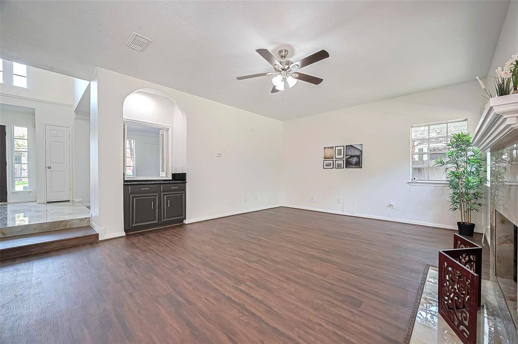 Spacious family room featuring a dry bar and an elegant ceiling fan with a light fixture