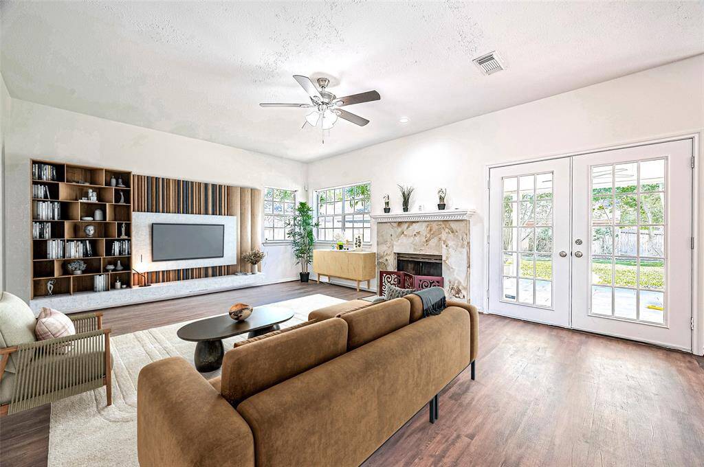 Virtual Staging: Family room features a Italian Marble Accent Fireplace with French doors opening to a covered patio