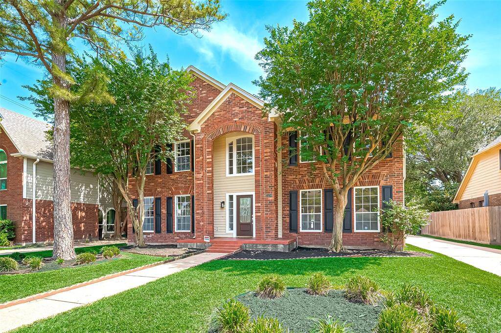 A brick veneer exterior beautifully complemented by a meticulously landscaped yard