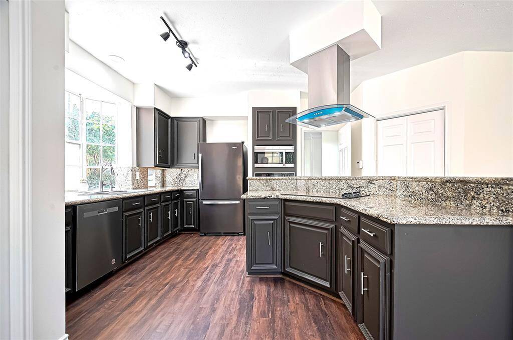 Kitchen Featuring track lighting, A Bay Window, Built in Dishwater and tall cabinets grace the space