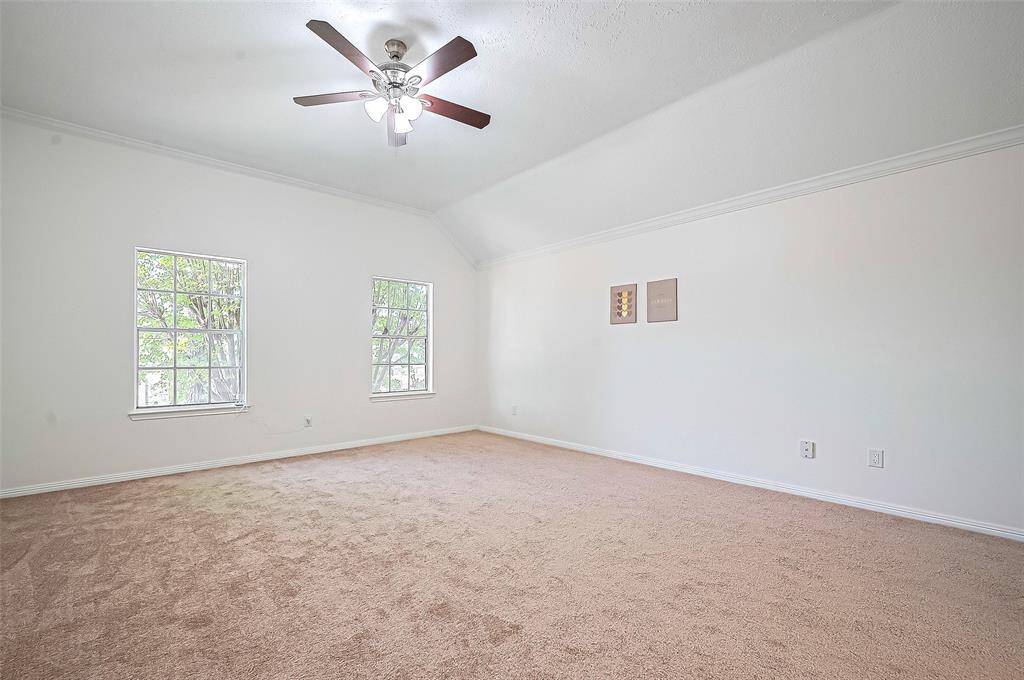The primary bedroom upstairs features a 10-foot ceiling, crown molding, and a light fixture adorned with crown molding