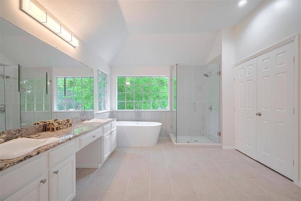 Newly renovated primary bathroom featuring vanities for him and her, adorned with marble counters