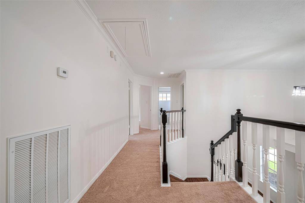 An upstairs foyer providing access to three bedrooms and a shared bathroom