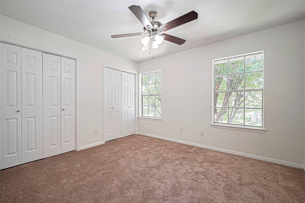Upstairs Bedroom #2 featuring two closet, a ceiling fan with light fixture and plenty of natural light