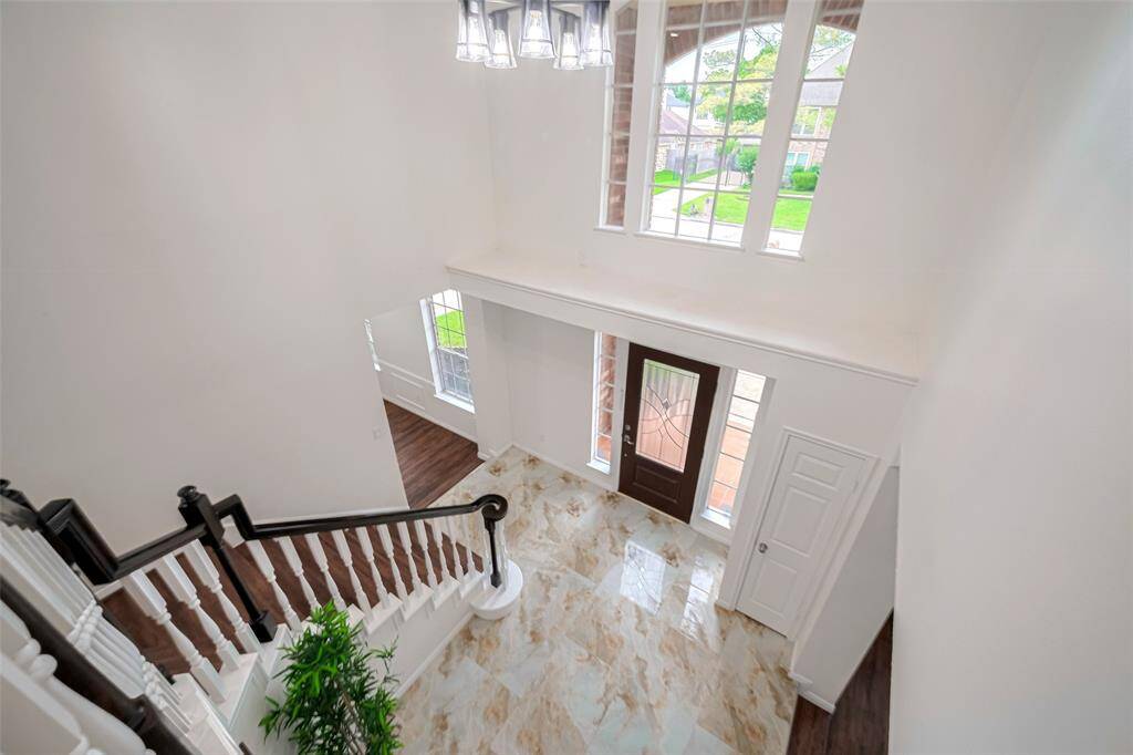 Expansive floor-to-ceiling windows invite an abundance of natural light while offering a picturesque view of Front yard