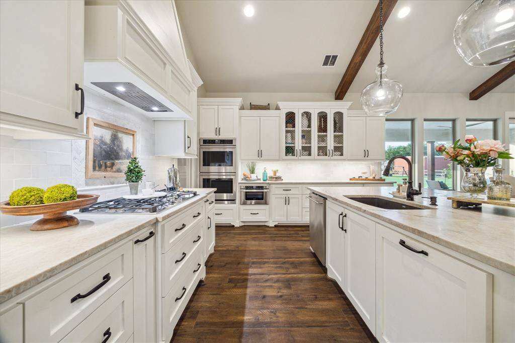 Gas cooktop framed by soft backsplash tile and generous countertop space - functional beauty at its finest.