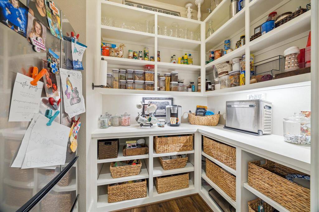 A dream pantry with floor-to-ceiling built-ins, woven basket storage, and a designated coffee nook to start your mornings right.