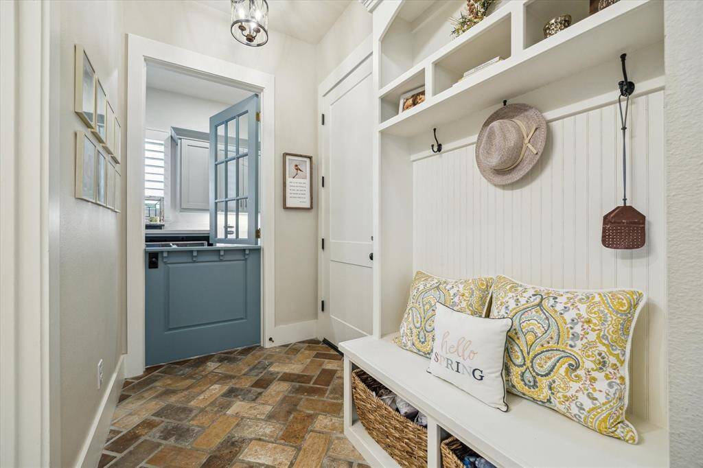 Charming Dutch door leads from a warm and welcoming mudroom into the laundry area - thoughtfully designed with storage and function in mind.