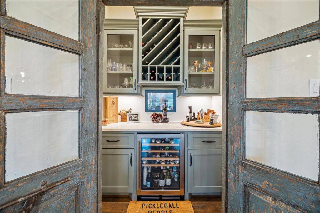 A hidden gem for entertaining - this built-in wine bar features a beverage fridge, wine rack, and statement doors.