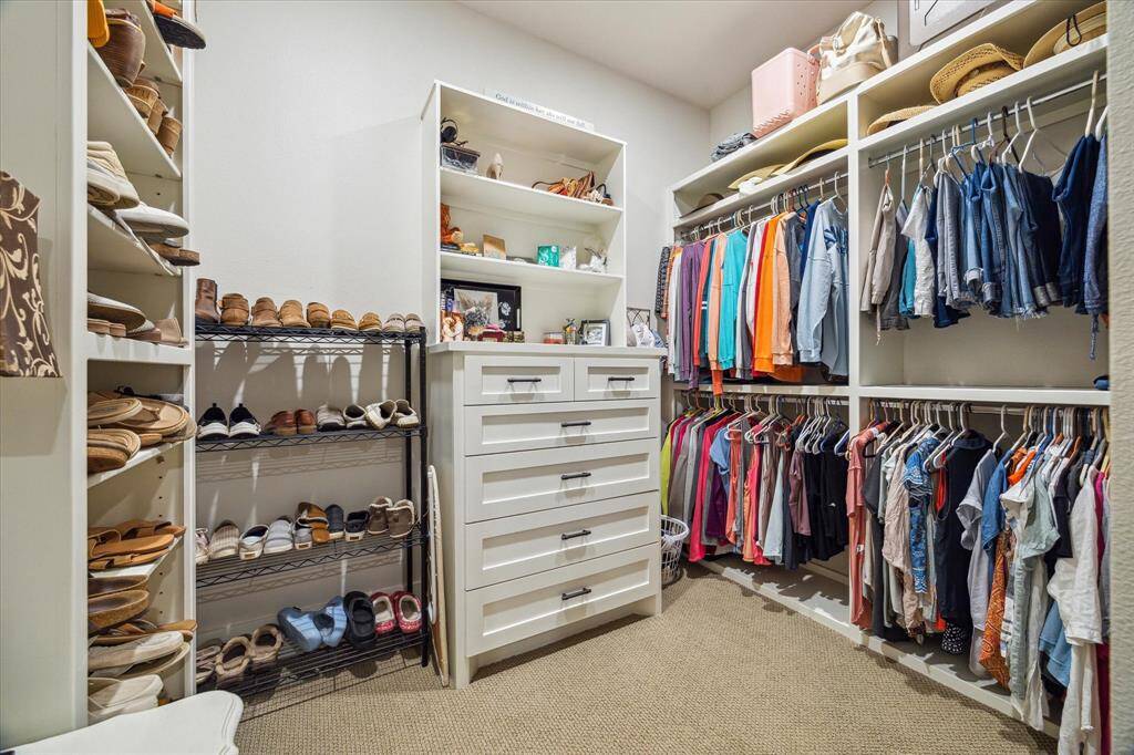 A beautifully arranged walk-in closet with boutique-style shelving, drawer space, and room for your full wardrobe.