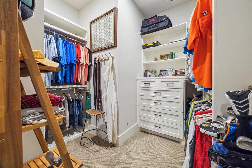 Custom-designed men’s closet with built-in drawers, shelving, and ample hanging space - organized and spacious.