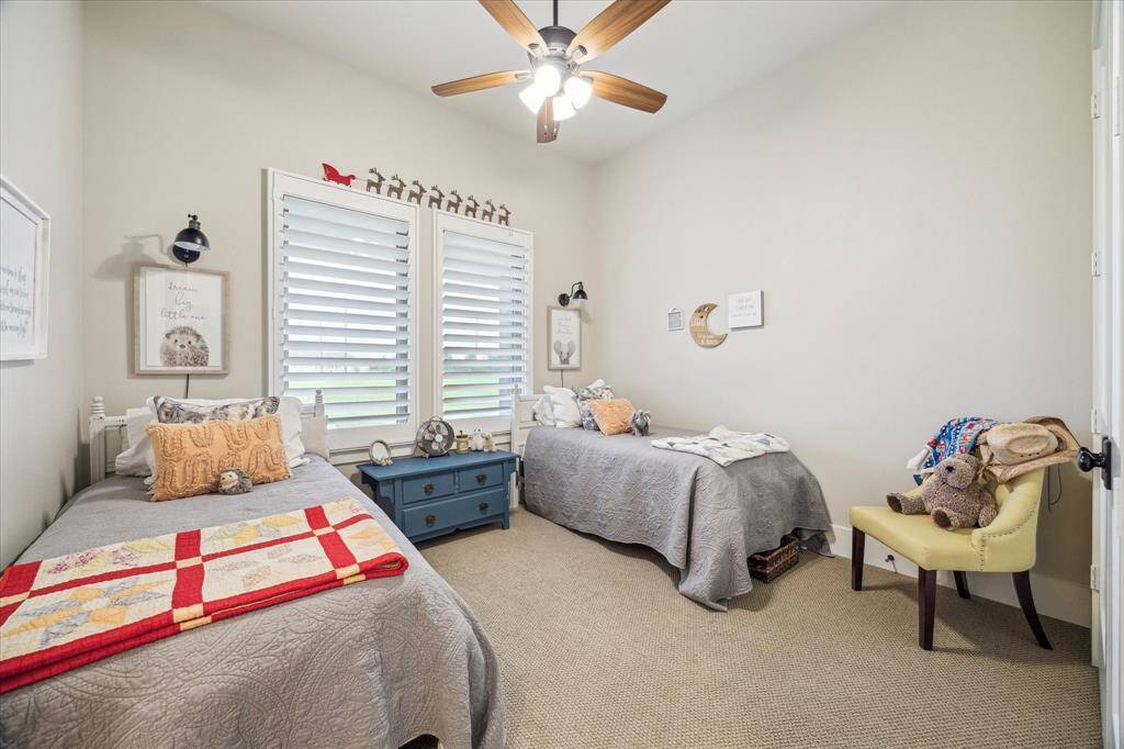 Charming guest or children’s room with twin beds, plantation shutters, and whimsical feel.