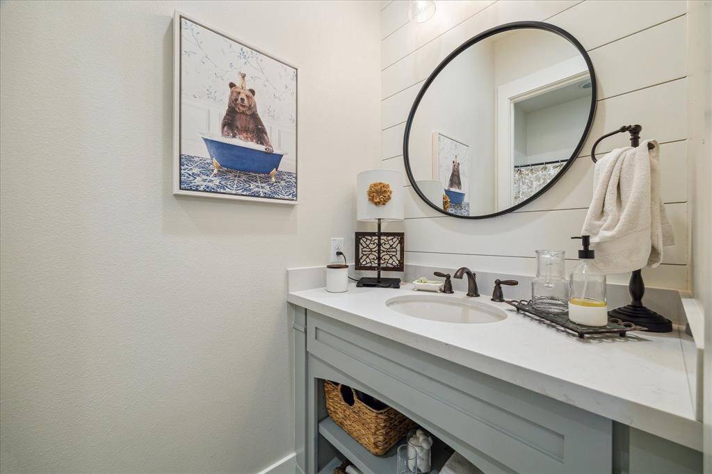 Bright, welcoming bathroom with quartz counters, built-in storage, and personality-this jack and jill set up is so smart and functional.