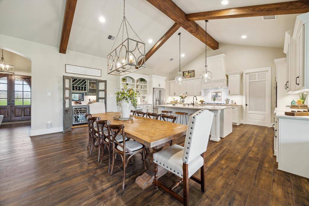 Spacious and inviting kitchen with vaulted ceilings, exposed beams, and open flow into dining and living - perfect for everyday rhythm or entertaining.
