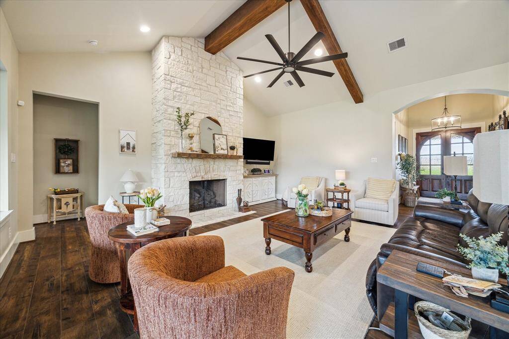An inviting living space with tray ceilings, natural light, and thoughtful flow into the foyer and kitchen.