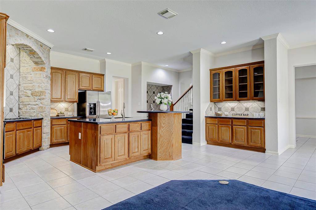 Another view of the bright and open kitchen with under cabinet lighting. A second staircase leads to the second floor rooms.