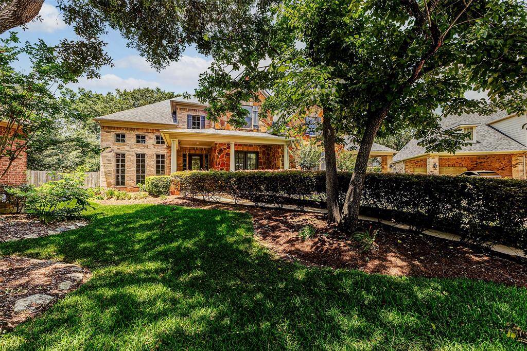 This delightful home features a classic brick & stone exterior with a welcoming front porch, shaded by mature trees. Perfect for enjoying outdoor living in a serene neighborhood.