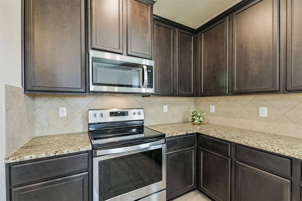 Granite counters, tile backsplash, built-in microwave provide function and beauty to this kitchen.