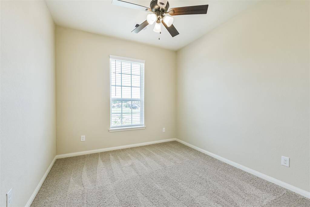 Third bedroom with ceiling fan looks to the front.