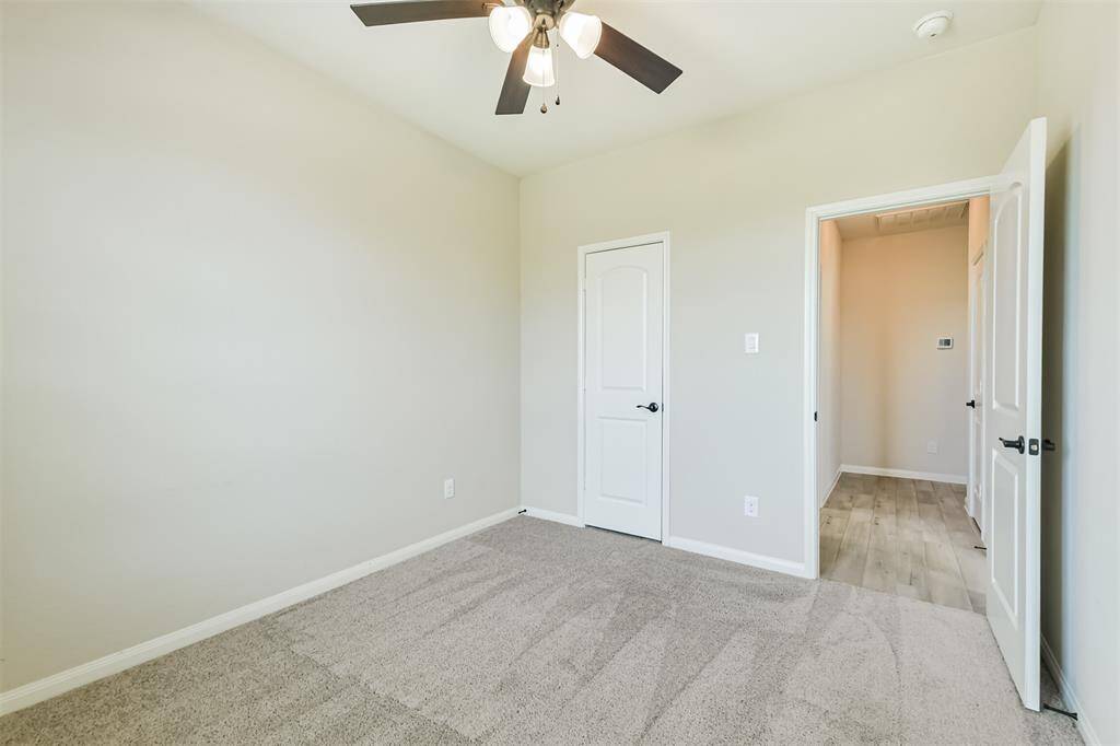 Third bedroom with large closet and ceiling fan.