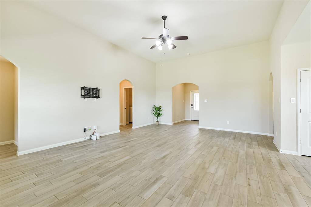 Lovely arched doorways lead off of the living room, adding a touch of elegance.