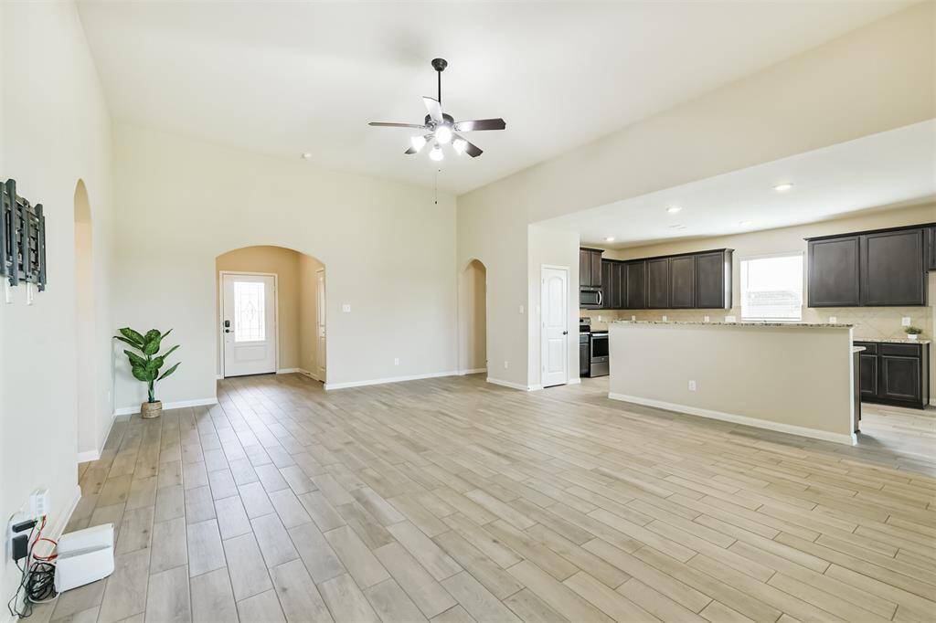 Spacious living room with wood look tile and high ceiling