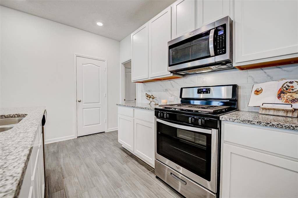 With crisp white cabinetry, gleaming countertops, and a gas range perfect for creating your signature dishes, this light and bright space is truly the heart of the home.