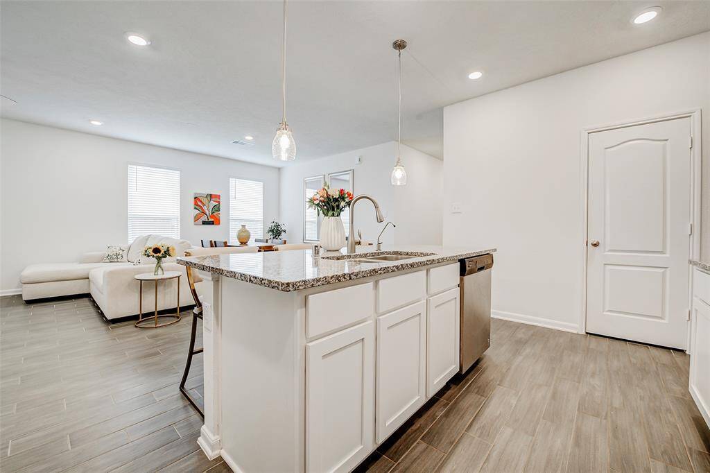 The spacious island offers seating for friends and family to gather, while expansive windows surround the space in natural light and provide views into the open-concept living and dining areas. Large walk-in pantry located behind that door on the right.