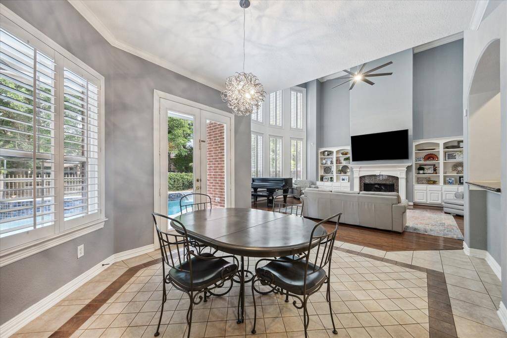 Breakfast Room with Backyard Views: Elevated ceilings, designer lighting, and 8’ double doors open to the pool and preserve—providing scenic views at every meal.