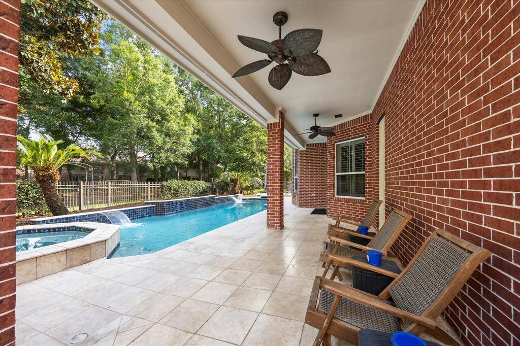 Resort-Style Backyard with Nature at Your Back Door: Thoughtfully designed for year-round enjoyment, this outdoor retreat offers pool with waterfall features, an elevated spa, an expansive 31’ covered patio, and green space left over.