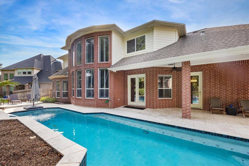 Architectural Beauty from the Backyard: The home’s curved window wall and covered patio make just as much of a statement from the outside—bringing elegance and shade to your outdoor living.