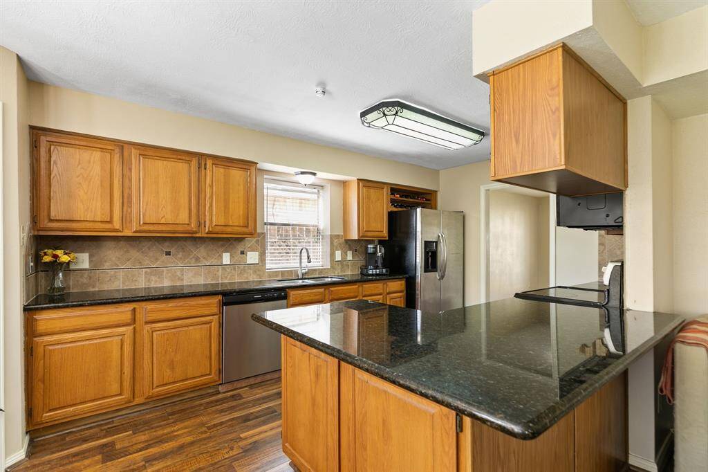 The kitchen boasts beautiful granite countertops, providing a durable surface for meal prep. The oak cabinets provide abundant storage space for all your kitchen essentials and there is even a window above the sink supplying natural light to the kitchen