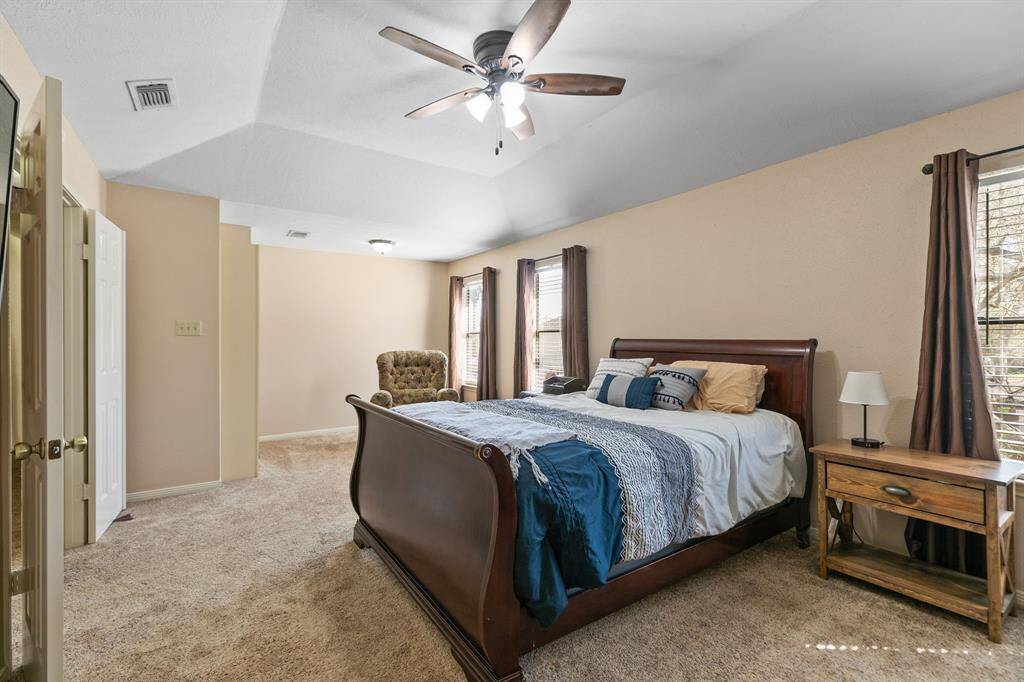 Upstairs, the oversized primary bedroom greets you with it's high ceiling and an abundance of natural light pouring in through the three large windows. A ceiling fan adds comfort, while double doors make it easy to bring large furniture into the room