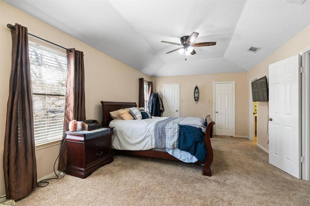 View of the primary bedroom from the sitting area. On the back wall, there is one large closet connected by two doors. Plenty of space for your clothes!