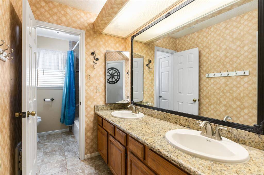 Upstairs is a full second bathroom with double sinks, granite counters, framed mirror and a linen closet. The laundry chute is located in this bathroom right behind the door