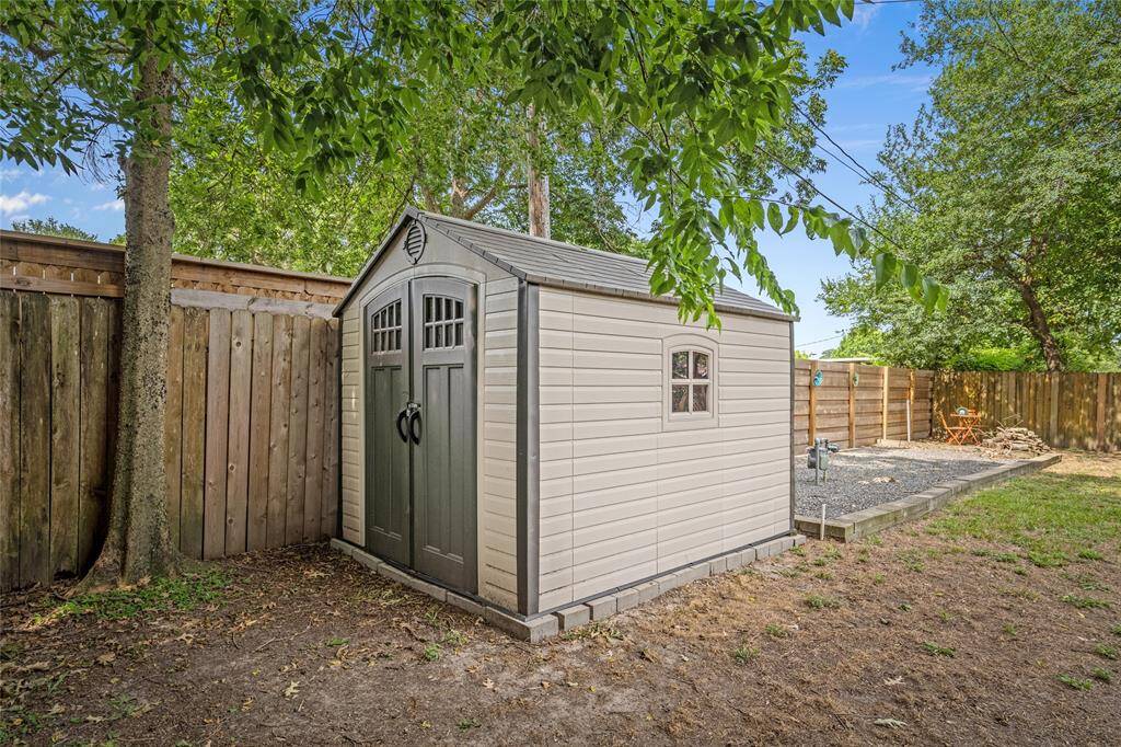 The backyard includes a handy outdoor storage shed, perfect for keeping tools, equipment, and seasonal items.