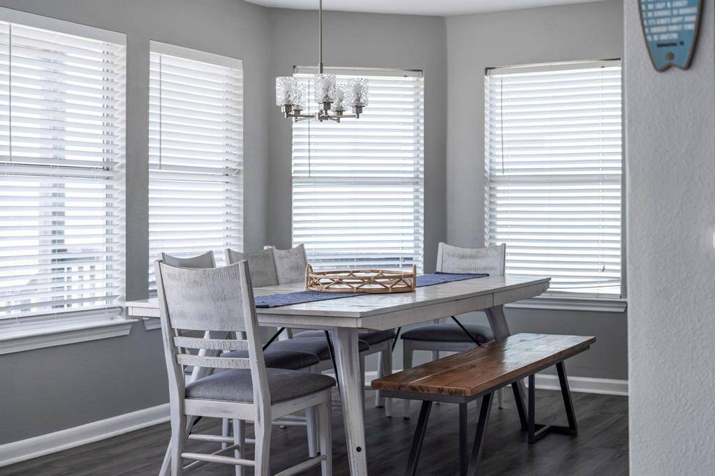 Charming dining nook surrounded by windows offers natural light and peaceful views—an inviting setting for casual meals or family dinners.