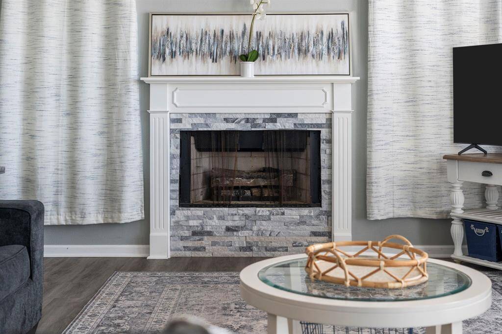 Statement fireplace with stacked stone surround and custom wood mantle brings warmth and charm to the main living space.