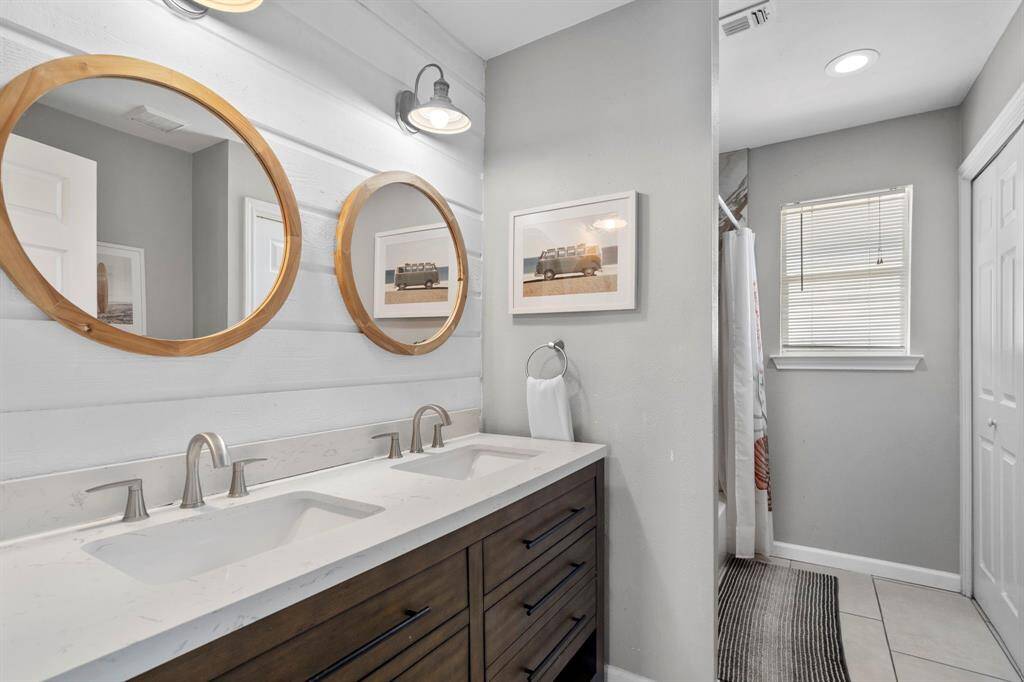 Fully updated bathroom with dual sinks, custom mirrors, and modern finishes, offering both style and functionality.