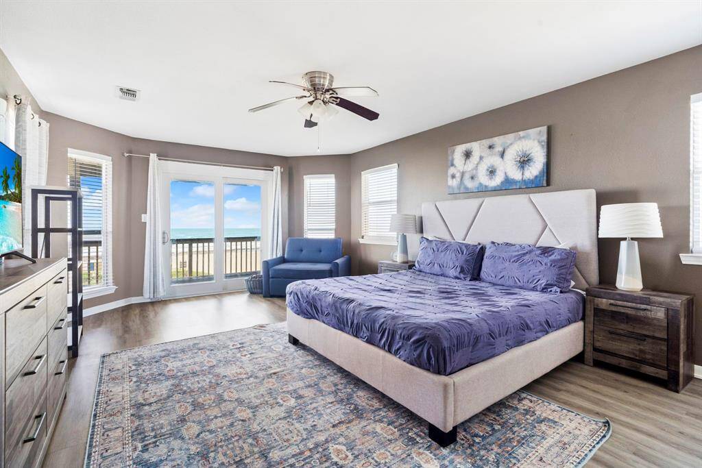 Bold and inviting secondary bedroom featuring deep blue accent walls, modern flooring, and great natural light—an ideal space for guests or family.