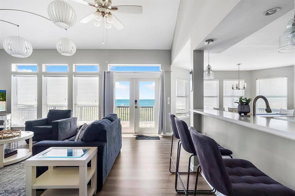 Cozy up in the living room with panoramic Gulf views, vaulted ceilings, and easy access to the covered deck—perfect for soaking in the sea breeze.