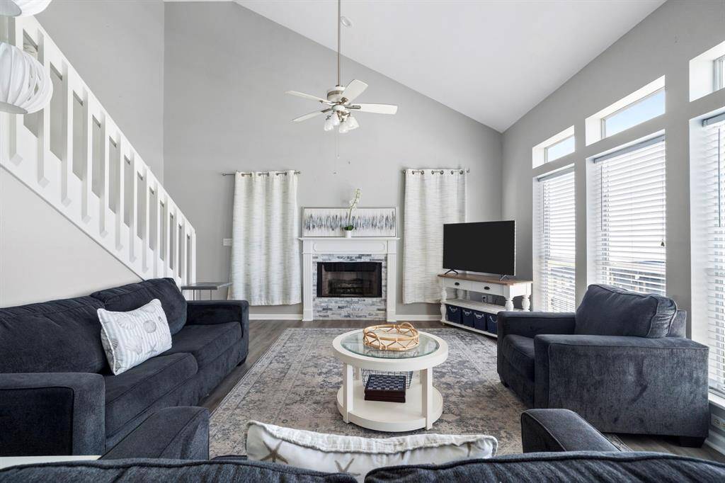Bright and airy living room with soaring ceilings, large windows, and a seamless layout for relaxing or entertaining.