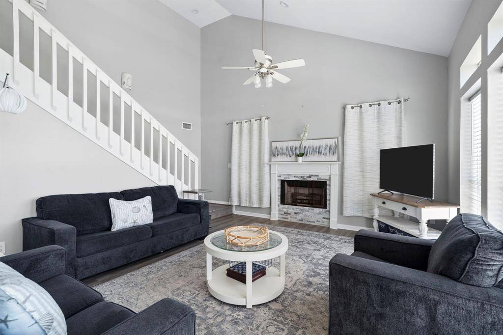 Coastal comfort at its finest—this welcoming living area features stylish furnishings and a striking fireplace centerpiece.
